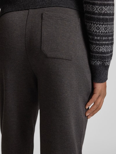 Męski model nosi Sweatpants mit elastischem Bund od Polo Ralph Lauren, mieszanka bawełny, luźny krój, detailaufnahme tylnej kieszeni.