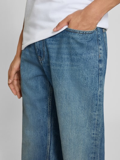 Männermodel trägt Baggy Jeans im klassischen 5-Pocket-Look von REVIEW aus reiner Baumwolle in Blau, Nahaufnahme Oberschenkel.