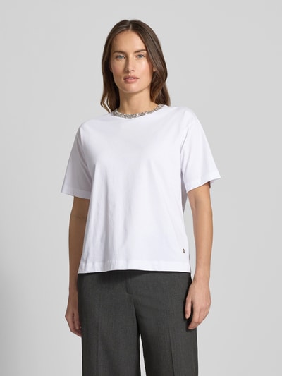 Kobiece model prezentuje białe T-shirt z bawełny JOOP! T-Shirt mit Label-Detail Modell 'Thei', luźny krój, widok całej sylwetki z przodu.