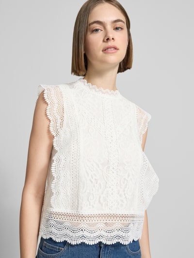 Frauenmodel trägt Slim Fit Blusentop mit Baumwoll-Viskose-Lyocell-Anteil Modell 'KARO' von Only, Optik: Unifarben, abstraktes Muster, Stehkragen, Rundhals, Nahtreißverschluss, ohne Ärmel, Material-Mix, Struktur mit feiner Lochspitze, helle Farbgebung, Nahaufnahme Oberkörper.
