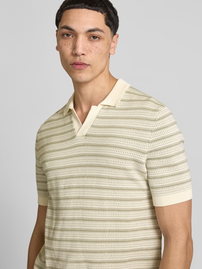 Männermodel trägt Regular Fit Poloshirt aus reiner Bio-Baumwolle Modell 'TILO' von Only & Sons in Optik:Allover-Muster, Nahaufnahme Oberkörper.