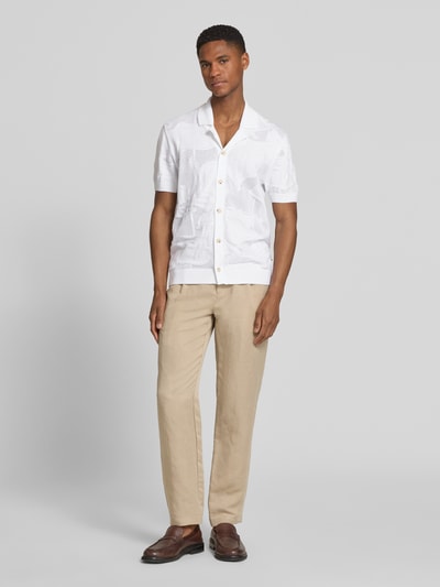 Männermodel trägt Regular Fit Freizeithemd aus Baumwoll-Strick Modell 'C-NOY' von BOSS in Weiß, unifarben mit Strickmuster, Resortkragen und Knopfleiste, gerippte Ärmel und Rumpf, reine Baumwolle, Ganzkörperansicht von vorne.