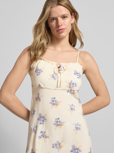 Frauenmodel trägt Schmales Freizeitkleid aus reiner Viskose Modell 'NELLY' von Only, cremefarben mit blauem und gelbem Allover-Blumenmuster auf Popeline, schmale Passform, Midi-Länge, Henley-Ausschnitt, Spaghettiträger, Nahaufnahme Oberkörper.