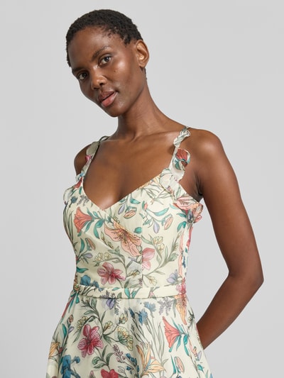 Frauenmodel trägt Cocktailkleid mit Herz-Ausschnitt von V.M., florales Muster in Pastellfarben, Volants, taillierte Passform, Nahaufnahme Oberkörper.