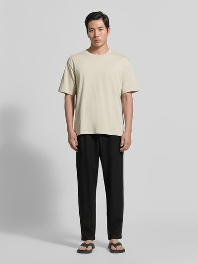 Mannenmodel draagt Tapered Fit Leinenhose met steekzakken van MCNEAL in zwart, zuiver linnen, tapered fit, paspelzakken achter, bandwijdte maat M 45 cm, binnenbeenlengte maat M 76 cm, volledige lichaamsaanzicht van voren.