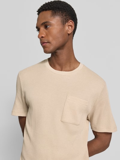 Mannelijk model draagt Regular Fit T-shirt uit katoenmix van s.Oliver RED LABEL in effen kleuren en gestructureerde look met borstzak, ronde hals, korte mouw, piqué materiaalverwerking, Nahaufnahme Oberkörper.