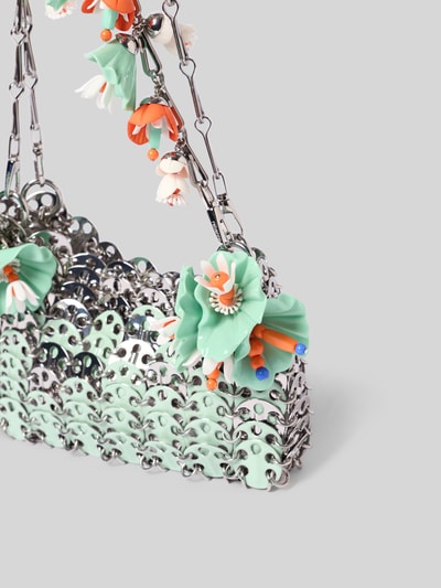 Produktfoto, Shoulder Bag in Ketten-Optik von Rabanne mit offenen Hauptfach, abnehmbaren Schulterriemen, floralen Applikationen, Logo-Prägung, silberne und mintgrüne Farben, strukturierte, reflektierende Textur, Breite 17 cm, Länge 10 cm, Tiefe 3 cm.