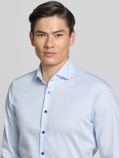 Męski model nosi Slim Fit Business Hemd mit Kentkragen von OLYMP Level Five, jasnoniebieskie paski, bawełniany elastyczny materiał, długi rękaw, durchgängige knopfkragen, długość tyłu w rozmiarze 40: 79 cm, szerokość ramion w rozmiarze 40: 40 cm, długość rękawa w rozmiarze 40: 65 cm, widok na górną część ciała z przodu