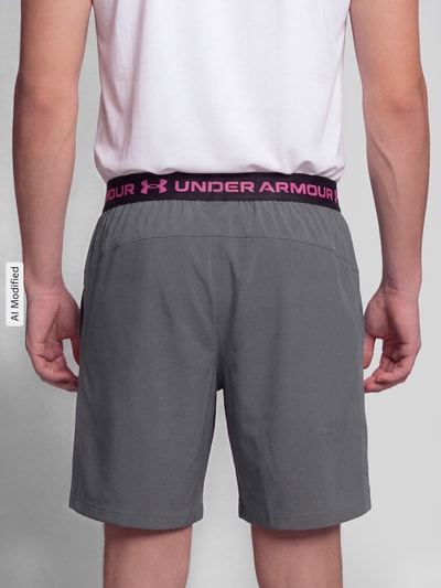Männermodel trägt Regular Fit Sportshorts mit logoprint van Under Armour in grijs, Heren Sportshorts, Ganzkörperansicht Rückansicht, KI-modifiziertes Bild.