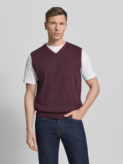 Männermodel trägt Pullunder mit Label-Stitching von Fynch-Hatton in Dunkelrot, Reine Baumwolle, Regular-Fit, gerippte Abschlüsse, V-Ausschnitt, Rückenlänge 66 cm, Ganzkörperansicht von vorne.