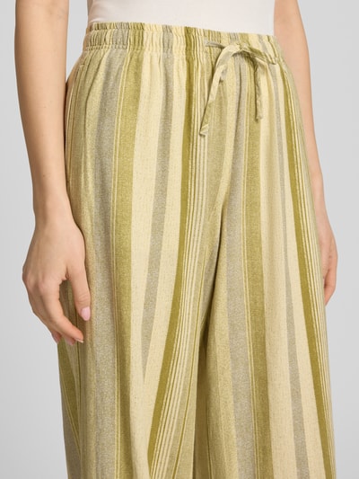 Kobieta nosi Hose aus Leinen-Viskose-Mix mit elastischem Bund Modell 'POLLY' od Topshop, jasne i oliwkowe paski, prosty krój, szerokość w rozmiarze 36: 34 cm, długość wewnętrzna nogawki 76 cm, zbliżenie na górną część spodni