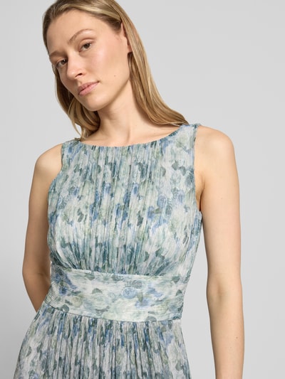 Frauenmodel trägt Cocktailkleid mit U-Boot-Ausschnitt von Swing, taillierte Passform, Midikleid mit Raffungen, sanfte Blautöne, Nahaufnahme Oberkörper. Rückenreißverschluss, Rückenlänge 118 cm, Brustweite 33 cm bei Größe 36.
