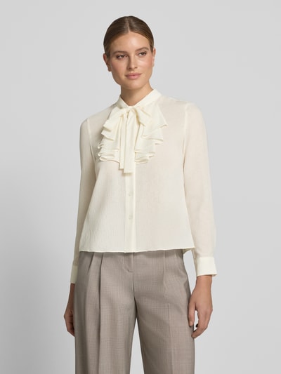 Vrouwenmodel draagt Regular Fit Schluppenbluse mit Rüschen van Christian Berg Woman Selection, crèmekleur met knoopsluiting, detailtextuur, dames blouse, voorkant bovenlichaam, ruglengte 57 cm, mouwlengte 60 cm.