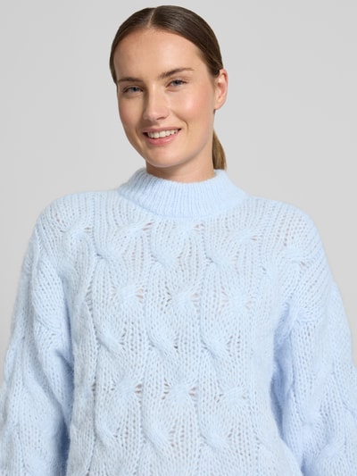 Frauenmodel trägt Regular Fit Pullover mit Rundhalsausschnitt Modell 'MAYBE' von VERO MODA in Hellblau, grobe Strickstruktur, Nahaufnahme Oberkörper, Damen Pullover von VERO MODA.
