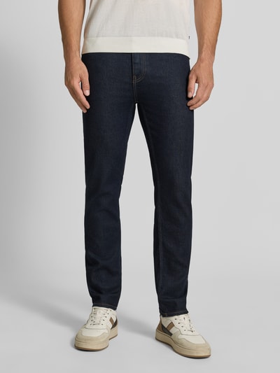 Männermodel trägt dunkelblaue Slim Fit Jeans aus Baumwoll-Mix Modell 'Delaware' von BOSS, glatte Textur, Ganzkörperansicht von vorne. Herren Slim Fit Jeans von BOSS.