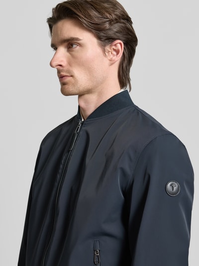 Männermodel trägt Regular Fit Jacke mit Stehkragen Modell 'Carlos' von JOOP! Collection, dunkelblau, Nahaufnahme Oberkörper. Elastischer Material-Mix, Reißverschluss, Eingrifftaschen, elastische Abschlüsse.
