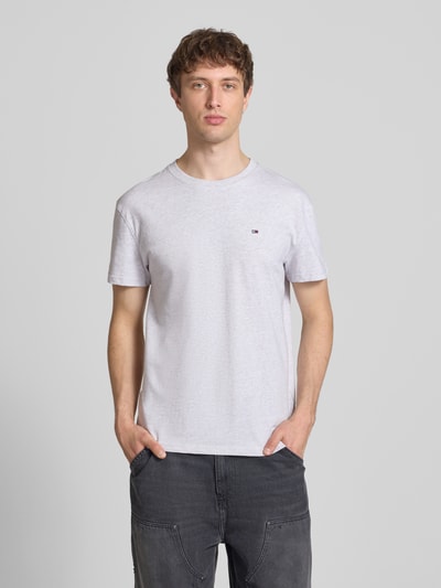 Männermodel trägt Regular Fit T-Shirt aus reiner Baumwolle von Tommy Jeans, unifarben, Logo-Stitching, Rundhals, Kurzarm, Ganzkörperansicht von vorne.