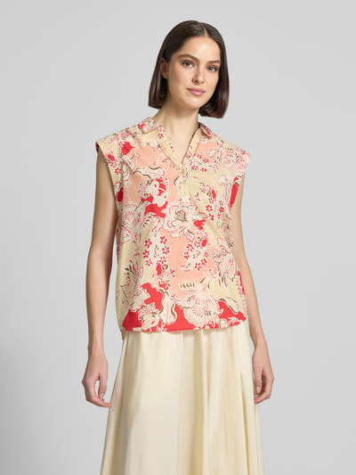 Frauenmodel trägt Blusentop mit kurzer Knopfleiste Modell 'FALDINE' von Soyaconcept aus Reine Baumwolle, Straight Fit, floraler Print, Kentkragen, V-Ausschnitt, sanfte Beige- und Rottöne, glatte leichte Textur, Rückenlänge bei Größe S: 64 cm, Ärmellänge bei Größe S: 5 cm, Ganzkörperansicht von vorne.