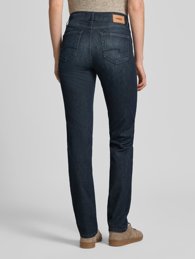 Frauenmodel trägt dunkelblaue Slim Fit Jeans im 5-Pocket-Design Modell 'CICI' von Angels, Baumwoll-Mix mit Stretch-Anteil, gerader Schnitt, Knopf- und Reißverschluss, Ganzkörperansicht Rückansicht.