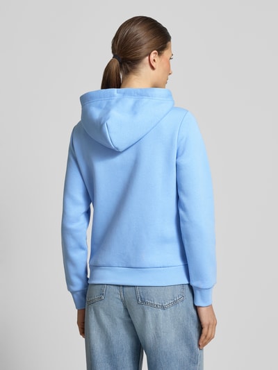 Frauenmodel trägt Sweatjacke mit Zweiwege-Reißverschluss und Label-Stitching von Gant, hellblauer Baumwoll-Mix, Rückansicht Ganzkörperansicht.