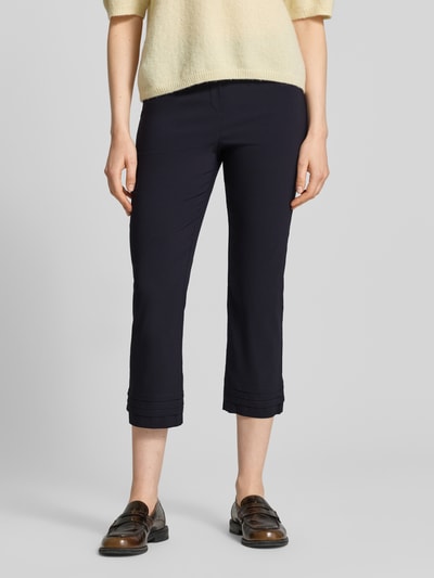Frauenmodel trägt Caprihose aus Viskose-Mix Modell 'Ina' von STEHMANN in Dunkelblau mit Drapierungen, Slim Fit, Nahaufnahme Oberkörper.