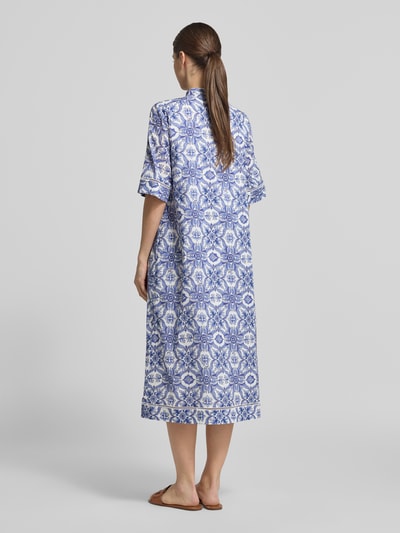 Frauenmodel trägt Midikleid mit verdeckter Knopfleiste Modell 'Desa' von JOOP!, blau-weiß gemustert aus reiner Baumwolle, gerader Schnitt, Ganzkörperansicht Rückansicht.
