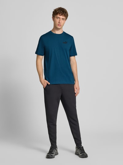 Männermodel trägt Regular Fit T-Shirt mit Logo-Stitching von PUMA PERFORMANCE, Reine Baumwolle, Rundhalsausschnitt, Herren T-Shirt, Ganzkörperansicht von vorne. Rückenlänge bei Größe M: 67 cm.