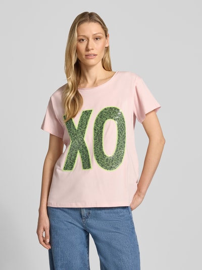 Frauenmodel trägt T-Shirt mit Paillettenbesatz von miss goodlife in Rosa mit grünem Schriftzug, Baumwoll-Elasthan-Mix, Rundhalsausschnitt, gerader Schnitt, Nahaufnahme Oberkörper.