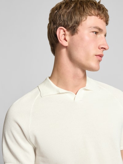 Mannelijk model draagt regular fit poloshirt met structuurpatroon model 'HILL' van Jack & Jones, puur katoen, v-hals, detailopname bovenlichaam.