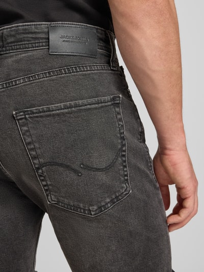 Männermodel trägt Regular Fit Jeansshorts mit Umschlag Modell 'RICK' von Jack & Jones, dunkles Denim, Detailaufnahme Rückansicht. Baumwoll-Elasthan-Mix, Eingrifftaschen.