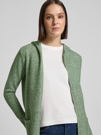 Frauenmodel trägt Regular Fit Cardigan mit Kapuze Modell 'DOFFY' von VERO MODA in meliertem Hellgrün, weiche Textur, Nahaufnahme Oberkörper.