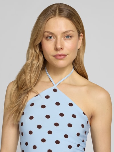 Modelka nosi top z wiązaniem na szyi w wzór w kropki na całej powierzchni, model 'Bowie' od Forever New, mieszanka materiałów z dodatkiem streczu, dopasowany krój, długość tyłu w rozmiarze 36: 24 cm. Nahaufnahme Oberkörper.