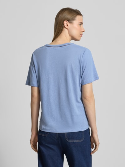 Frauenmodel trägt Relaxed Fit T-Shirt aus Leinen-Mix mit V-Ausschnitt von Scotch & Soda in Hellblau mit Lochmuster, Rückenlänge 60 cm, Ganzkörperansicht Rückansicht.