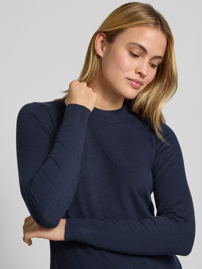 Frauenmodel trägt Slim Fit Strickpullover mit elastischen Abschlüssen von Christian Berg Woman, dunkelblau, glatte Textur, Nahaufnahme Oberkörper. Material-Mix mit Viskose-Anteil, Rundhalsausschnitt, Damenschnitt.
