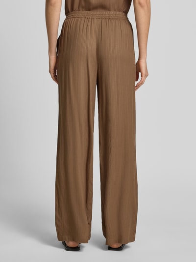 Frauenmodel trägt Wide-Leg-Pants mit elastischem Bund Modell 'INA' von Vila aus Reine Viskose, ausgestellt, mit Eingrifftaschen, Ganzkörperansicht Rückansicht.