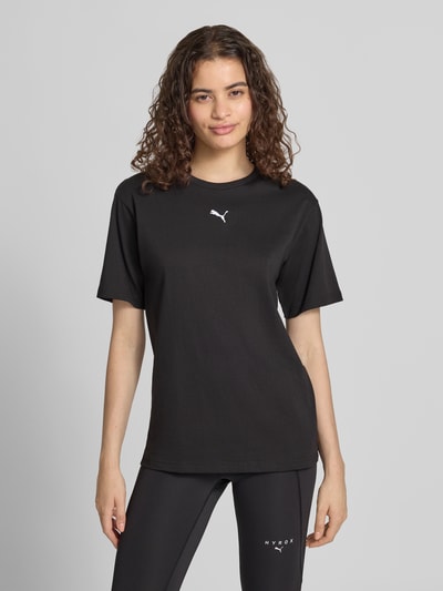 Frauenmodel trägt T-Shirt mit Label-Stitching und Rundhalsausschnitt von PUMA in Schwarz, reine Baumwolle, Regular Fit, Ganzkörperansicht von vorne