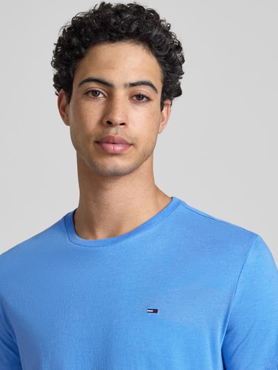 Męski model nosi Slim Fit T-Shirt Modell 'TJM XSLIM JASPE HTR TEE E' von Tommy Jeans, efekt: jednolity kolor, krój slim fit, wyhaftowane logo, dekolt w serek, krótki rękaw, zbliżenie na górną część ciała