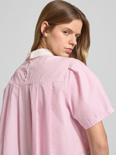 Frauenmodel trägt Boxy Fit Bluse aus reiner Baumwolle von Marc O'Polo Denim in mehrfarbiger Optik mit Streifen-Muster, Hemdblusenkragen, Kurzarm, Rückenpasse, verdeckte Knopfleiste hinten und Schriftzug, aus Popeline-Material, Nahaufnahme Oberkörper Rückansicht.