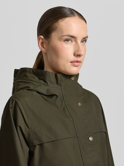 Modelka nosi Regular Fit Funktionsjacke aus Baumwoll-Mix Modell 'BAYTHORPE' od Barbour, oliwkowy kolor, materiał bawełniany, kaptur, wodoodporna, oddychająca, patki na kieszeniach, krój regular fit, zbliżenie na górną część ciała.