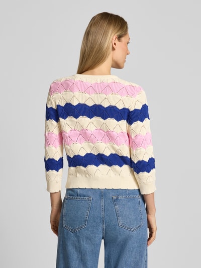 Frauenmodel trägt Strickjacke mit Knopfleiste und aufgesetzten Taschen von Rich & Royal, gestreiftes Muster in Creme, Rosa und Blau, reine Baumwolle, gerader Schnitt, Rückenlänge 48 cm, Ärmellänge 44 cm, Ganzkörperansicht Rückansicht.