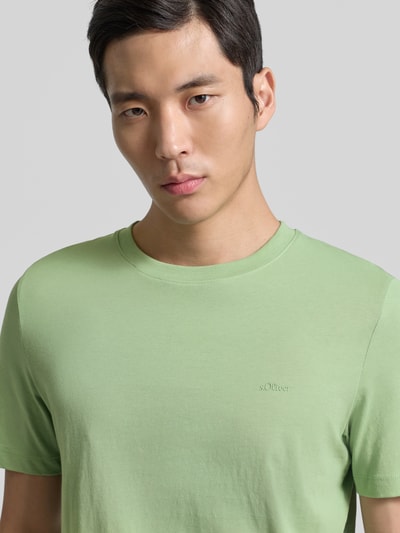 Männermodel trägt Regular Fit T-Shirt aus reiner Baumwolle von s.Oliver RED LABEL in uni Hellgrün, Jersey, Label-Stitching, Nahaufnahme Oberkörper.