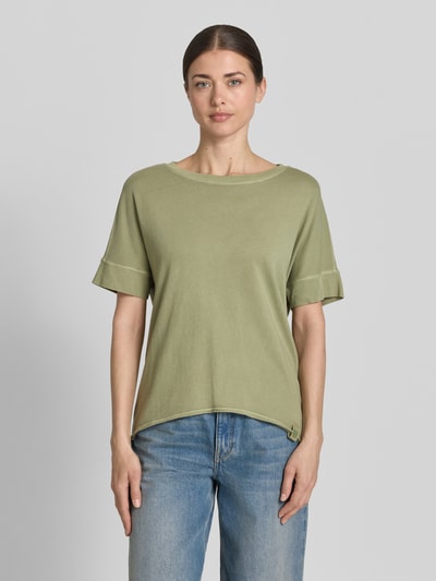 Modelka kobieca ma na sobie Relaxed Fit T-Shirt aus reiner Baumwolle od s.Oliver RED LABEL, kolor oliwkowy, krótki rękaw, okrągły dekolt, logo, bawełna, gładka faktura, widok całej sylwetki z przodu.