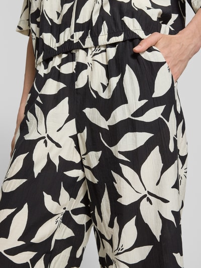 Kobiece modelka nosi Wide Leg Culotte aus Viskose-Mix od s.Oliver RED LABEL, czarno-biały allover-wzór, tkanina crêpe, kieszenie boczne, detailaufnahme bioder.