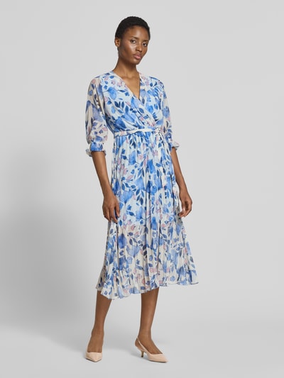 Frauenmodel trägt Midikleid im Allover-Look mit Bindegürtel von ZABAIONE in Blau und Weiß, A-Linie, V-Ausschnitt, Ganzkörperansicht von vorne.