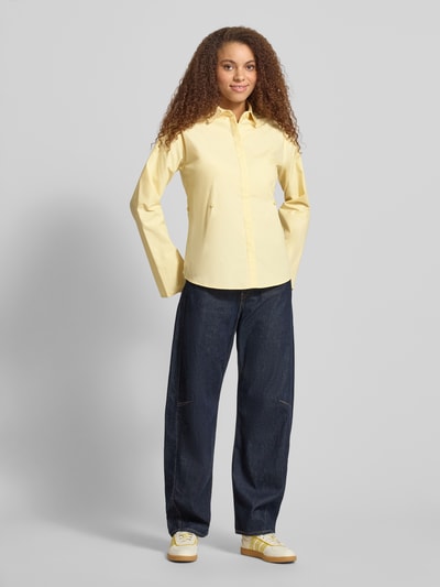 Frauenmodel trägt Regular Fit Bluse mit verdeckter Knopfleiste von Gina Tricot in Gelb, reine Baumwolle, Hemdblusenkragen, Ganzkörperansicht von vorne.