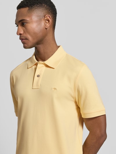 Männermodel trägt Regular Fit Poloshirt mit Logo-Stitching von Fynch-Hatton in Hellgelb, reine Baumwolle, Nahaufnahme Oberkörper.