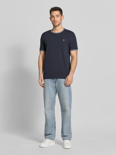 Männermodel trägt T-Shirt mit Kontraststreifen und Rundhalsausschnitt von Christian Berg Men aus Baumwoll-Elasthan-Mix im Regular-Fit, dunkelblau mit weißen Details, glatte Oberfläche, Rückenlänge bei Größe M 71 cm, Ganzkörperansicht von vorne.