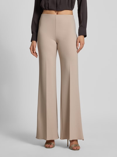 Vrouwenmodel draagt Flared Fit Stoffhose met Bügelfalten van Rinascimento, beige, met stretch, elastische band, persplooien, maat S, binnenbeenlengte 85 cm, bandwijdte 38 cm, materiaal-mix; vooraanzicht, detailopname onderlichaam.