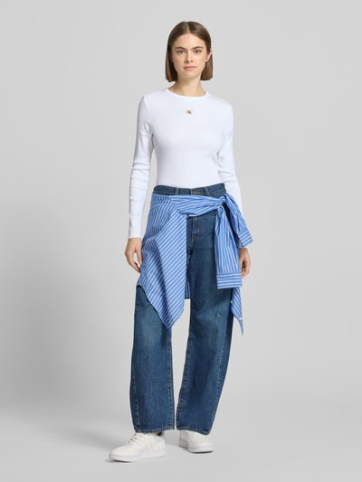 Vrouwenmodel draagt Longsleeve met Label-Detail van Calvin Klein Jeans, slim fit, witte katoen-elastaan mix, geribde ronde hals, voorkant volledig te zien.