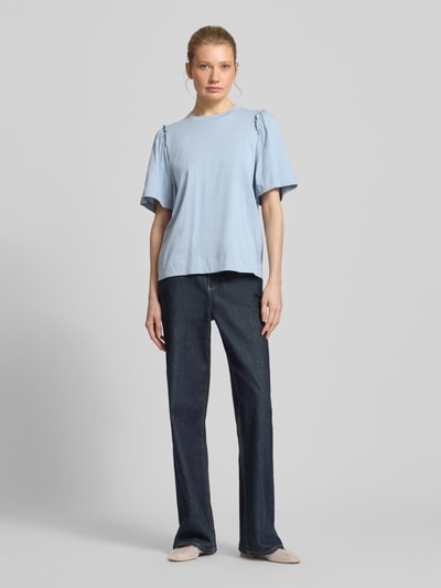 Modelka kobieca nosi Regular Fit T-Shirt aus reiner Baumwolle Modell 'PENELOPE' od Selected Femme, jasnoniebieski, gładki, rzęsy, okrągły dekolt, półrękaw, bawełna, pełny widok z przodu.